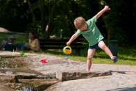 Kind mit Gießkanne Kind spielt mit einer Gießkanne