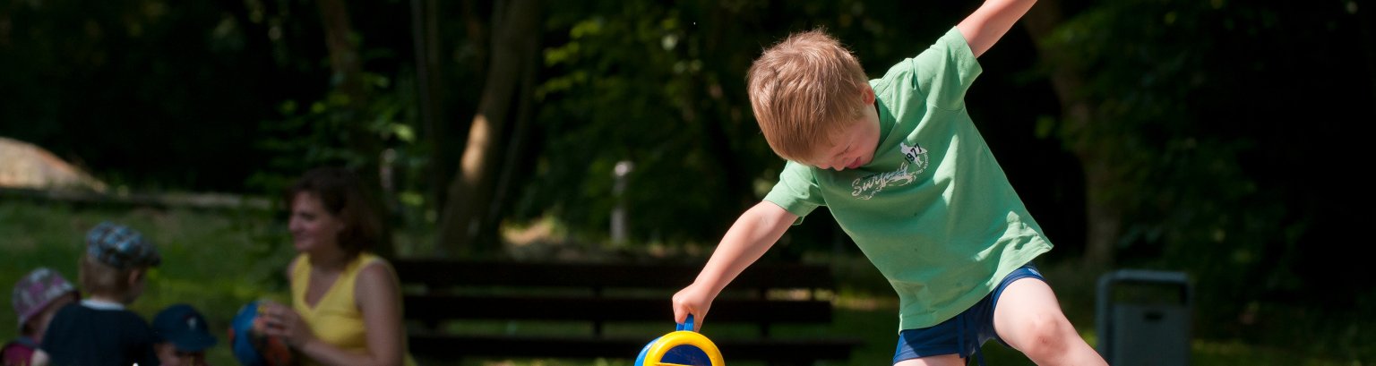 Kind spielt mit einer Gießkanne