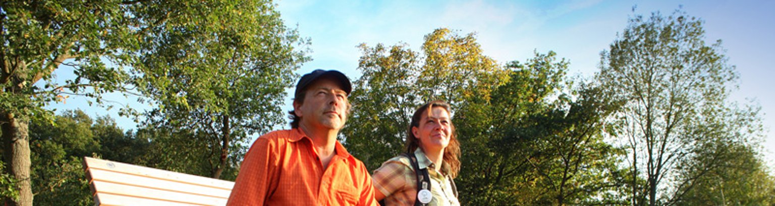 Wanderer auf der Bank Zwei Personen sitzen auf einer Bank an einem Wanderweg.